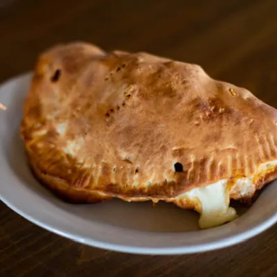 House made calzone with melted cheese at Spiro's Pizza & Pasta in Shoreline WA